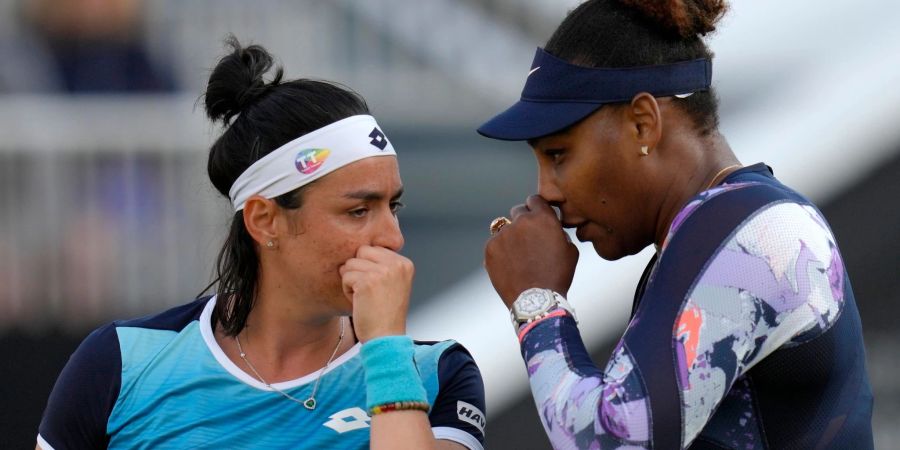 Serena Williams (r) und Ons Jabeur sprechen sich beim Doppel in Eastbourne ab.