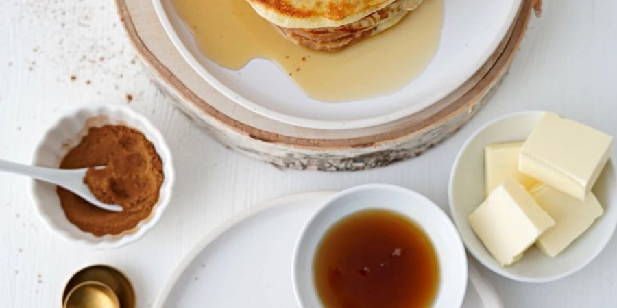 Die zweifarbigen Pancakes werden mit Ahornsirup und Butter serviert.