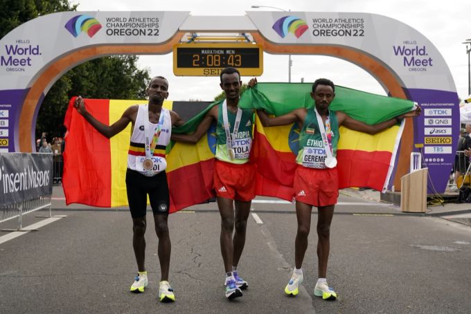 Der äthiopische Goldmedaillen-Gewinner Tamirat Tola (Mitte), sein Landsmann und Silbermedaillen-Gewinner Mosinet Geremew (rechts) und der belgische Bronzemedaille-Gewinner Bashir Abdi (links) nach dem Marathonlauf. marathonlauf