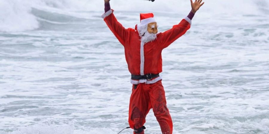 Surfende Weihnachtsmänner sieht man unter anderem in Brasilien. Dort markiert Weihnachten den Beginn des Sommers.