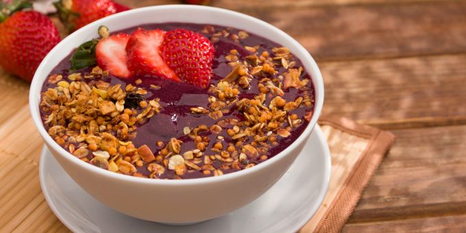 So kennen Sie die Açaí-Beere: als Paste in einer Smoothie-Bowl. Açaí Müsli Schale Holztisch.