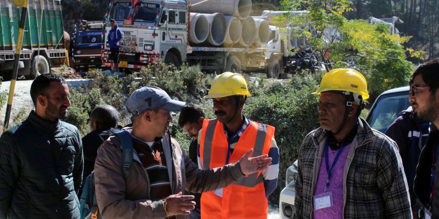 Retter beraten sich vor dem teilweise eingestürzten Strassentunnel im indischen Silkyara.