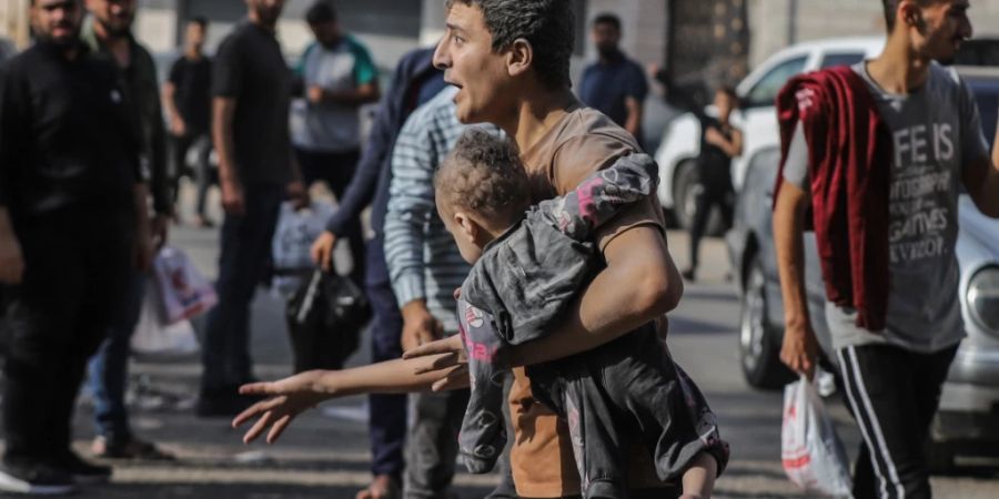 Mann trägt Kind Gaza