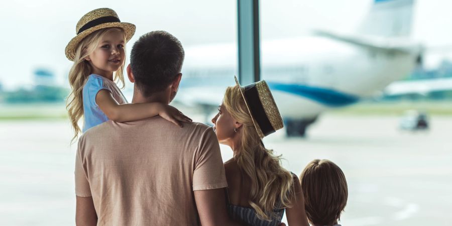 junge familie am flughafen, blick aufs rollfeld