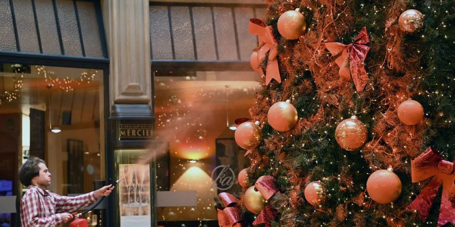 Ein Mitglied der Protestgruppe «Letzte Generation» besprüht einen Weihnachtsbaum in der Leipziger Mädler-Passage.