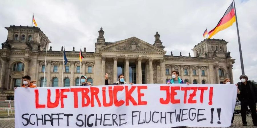 Demonstration für eine Luftbrücke aus Afghanistan vor dem Reichstagsgebäude in Berlin. Foto: Christoph Soeder/dpa