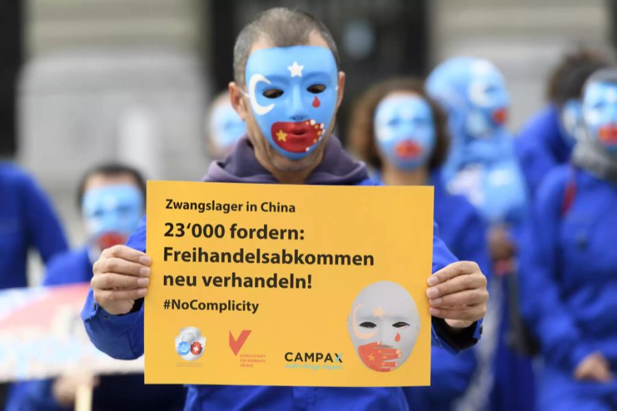 Ein Demonstrant mit Uiguren-Maske auf dem Bundesplatz in Bern bei der Einreichung der Petition zur Neuverhandlung des Freihandelsabkommens mit China.