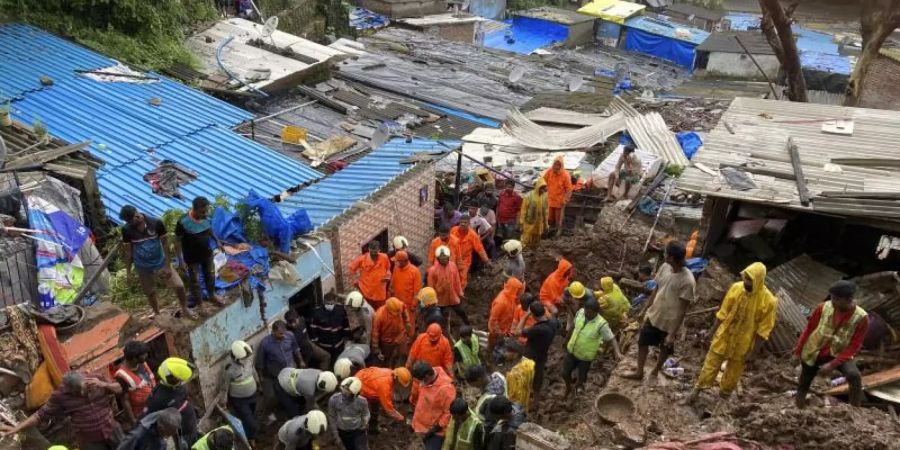Rettungskräfte sind nach dem Einsturz mehrerer Häuser im Einsatz. Foto: Rajanish Kakade/AP/dpa