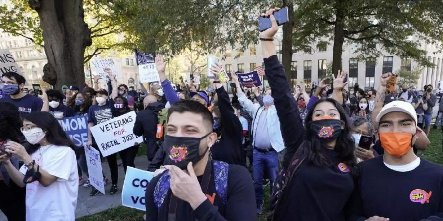 Menschen jubeln nach Bekanntgabe des Ergebnisses am Black Lives Matter Plaza in Washington. Foto: Alex Brandon/AP/dpa