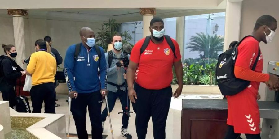 Der Kongolese Gauthier Mvumbi (2.v.r) geht mit seinen Teamkollegen von der Nationalmannschaft aus Kongo durch das Foyer des Teamhotels. Foto: Nils Bastek/dpa