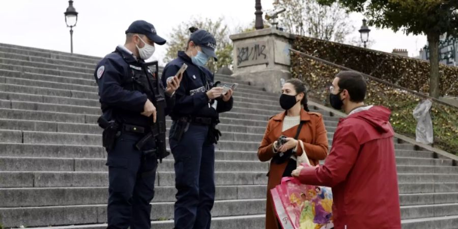 Die Polizei kontrolliert ein Paar in Paris