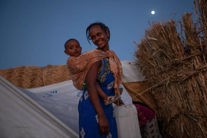 Eine Tigray-Frau, die vor dem Konflikt in der äthiopischen Region Tigray in den Sudan geflohen ist, trägt ihr Baby in der Nähe ihrer Unterkunft im Flüchtlingslager Umm Rakouba in Qadarif, Ostsudan. Konflikt in Äthiopien