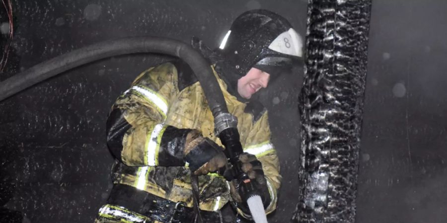 HANDOUT - Ein Feuerwehrmann am Brandort an einem Altenheim. Foto: Uncredited/Russian Emergency Ministry Press Service/AP/dpa - ACHTUNG: Nur zur redaktionellen Verwendung und nur mit vollständiger Nennung des vorstehenden Credits