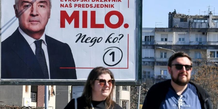 Passanten in Podgorica vor Djukanovic-Wahlplakat