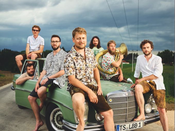 LaBrassBanda spielt am «magic blue»-Openair. Band sitzt auf Auto