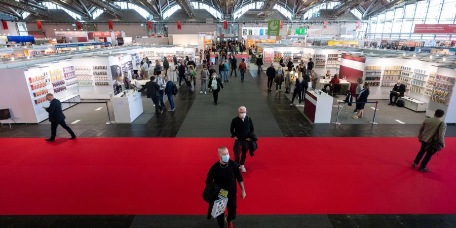 Menschen gehen während des ersten Besuchertags der Frankfurter Buchmesse 2021 durch die Halle 3.1.