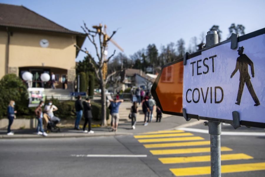 Menschen stehen vor einem Corona-Testcenter in Lausanne Schlange.