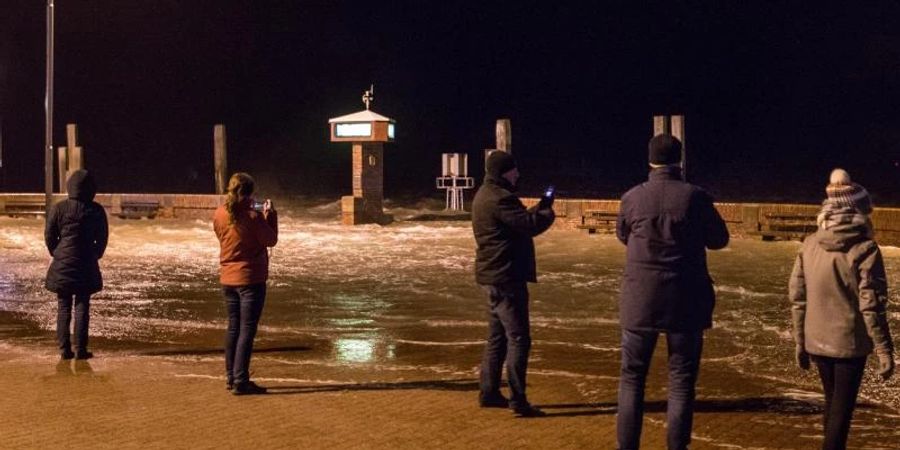 Eine Sturmflut überspült die Mole im Hafen von Norddeich in Ostfriesland. Foto: Lennart Stock/dpa
