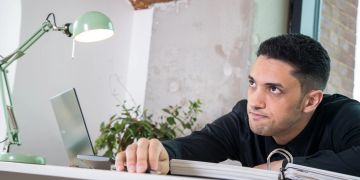 Mann Schreibtisch genervter Gesichtsausdruck