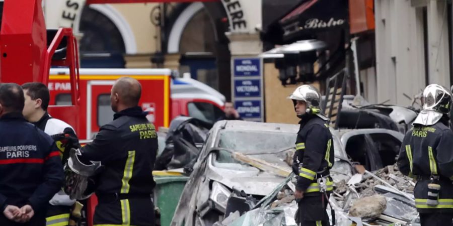 ARCHIV - Feuerwehrleute stehen in der Nähe des Unfallortes einer Gasexplosion in einer Pariser Bäckerei. Drei Jahre nach der schweren Explosion mit vier Toten und Dutzenden Verletzten sollen die Opfer eine Entschädigung bekommen. Paris wolle 20 Millionen Euro bereitstellen, teilte das Rathaus am Dienstag mit. Foto: Christophe Ena/AP/dpa