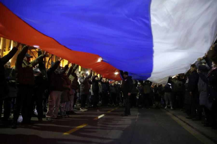 Demonstranten schwingen eine grosse russische Fahne an der pro-russischen Kundgebung vom 4. März 2022 in Belgrad.