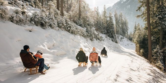 Eine Schlittenfahrt umgeben von einer schönen Winterkulisse sorgt bei Gross und Klein für ein Lachen auf dem Gesicht. BLS Winterausflüge Naturpark Diemtigtal