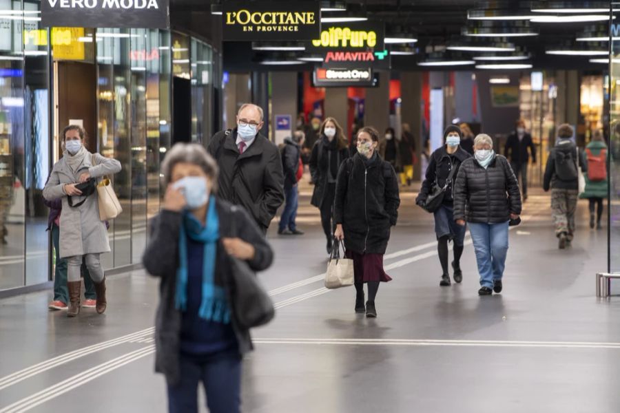 Zugreisende mit Schutzmaske im Bahnhof Bern.