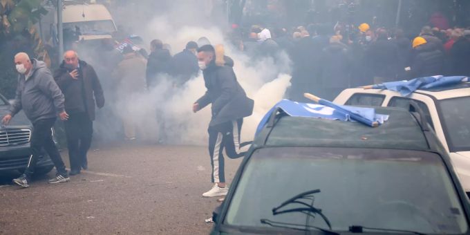 Protestierende rennen in Albaniens Hauptstadt Tirana vor der Polizei, welche Tränengas einsetzt, davon. albanien
