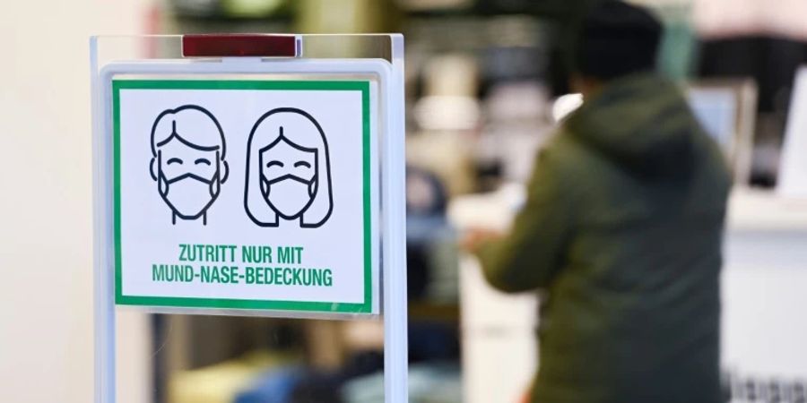 Hinweis auf Maskenpflicht an einem Geschäft in Essen