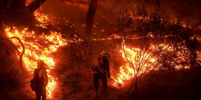 Mitarbeiter der Behörde für Forstwesen und Brandschutz arbeiten zwischen den Flammen eines Waldbrandes. Foto: Kent Porter Waldbrände in Kalifornien