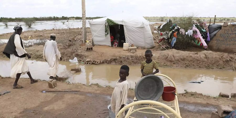 Zwei kleine sudanesische Jungen stehen vor ihrer provisorischen Unterkunft am Strassenrand, etwa 60km von der Hauptstadt entfernt. Sintflutartige Regenfälle haben Häuser und die Infrastruktur im ganzen Land verwüstet. Mehr als 50 000 Menschen sind nach Angaben der Vereinten Nationen betroffen. Foto: Marwan Ali/AP/dpa