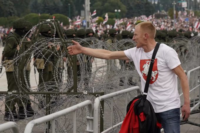 Ein Mann gestikuliert und versucht, ein Gespräch mit Sicherheitskräften während Protesten in Minsk anzufangen. Minsk