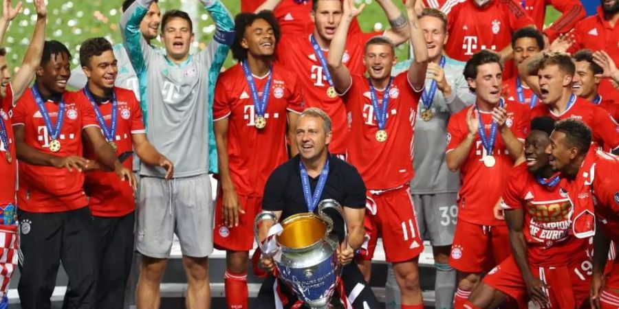 Hat mit dem FC Bayern München das Triple geschafft: Cheftrainer Hans-Dieter Flick (M) bei der Siegerehrung. Foto: Julian Finney/Getty Images via UEFA/dpa