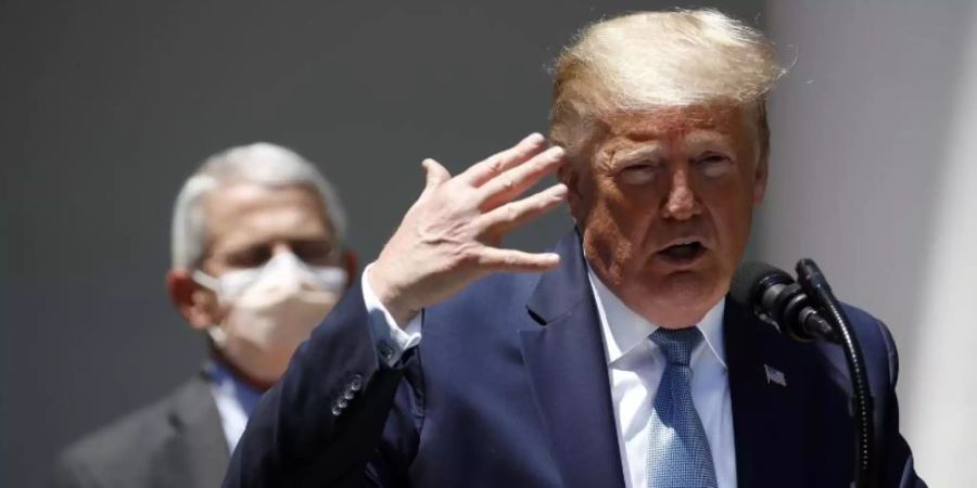 Donald Trump Mitte Mai bei einer Pressekonferenz im Rosengarten des Weissen Hauses. Im Hintergrund Anthony Fauci. Foto: Alex Brandon/AP/dpa