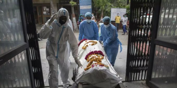 Ein Corona-Toter in Neu Delhi wird vom Pflegepersonal abtransportiert. Indien