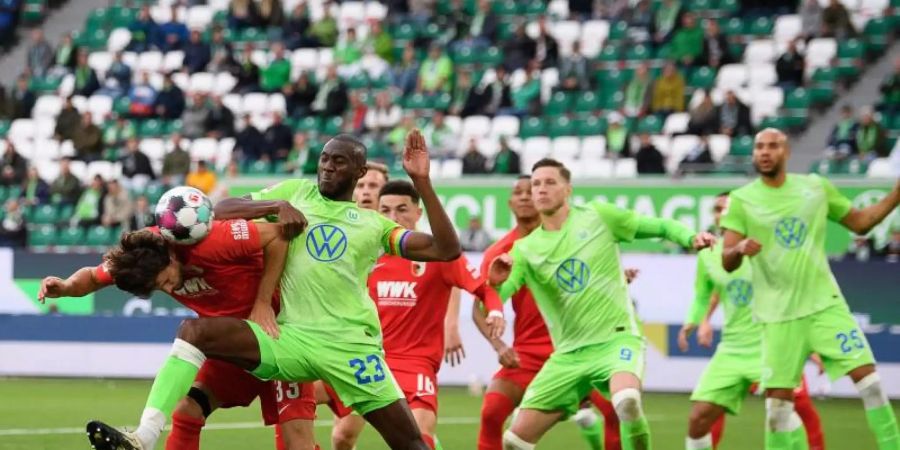 Josuha Guilavogui (3.v.l.) vom VfL Wolfsburg und Tobias Strobl, Spieler beim FC Augsburg, kämpfen um den Ball. Foto: Swen Pförtner/dpa
