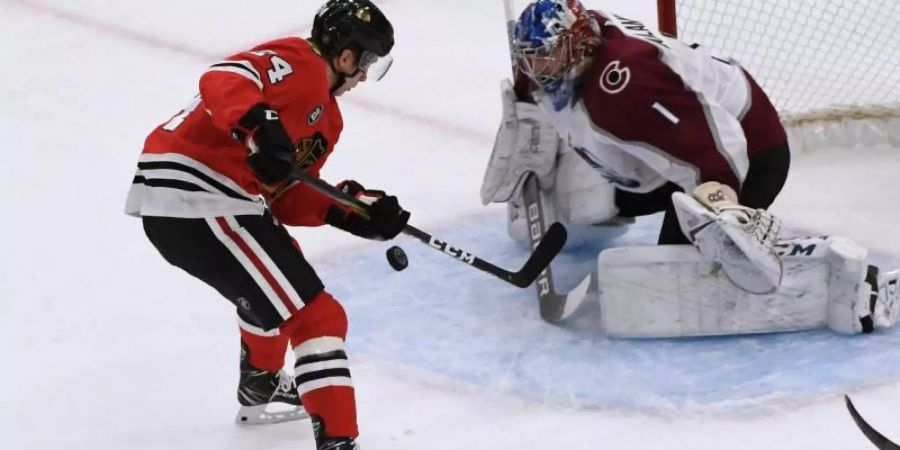 Blackhawks-Spieler Dominik Kahun (l) schiesst auf das Tor von Goalie Semjon Warlamow von Colorado Avalanche. Foto: David Banks/AP
