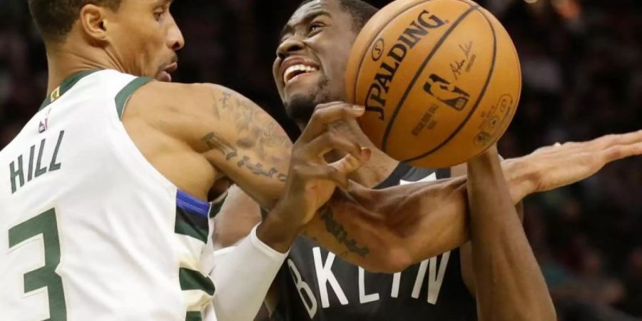 George Hill (l) von den Milwaukee Bucks foult Caris LeVert von den Brooklyn Nets. Foto: Jeffrey Phelps/FR59249 AP/dpa