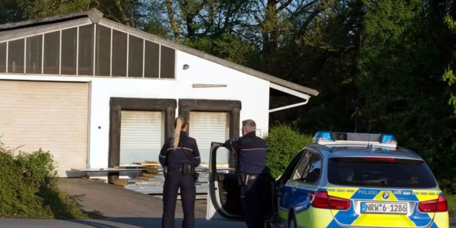 Polizeibeamte stehen vor einer Lagerhalle in der 35.000 Liter verschiedener Chemikalien und 50 Propangasflaschen entdeckt wurden. Foto: Oliver Krato
