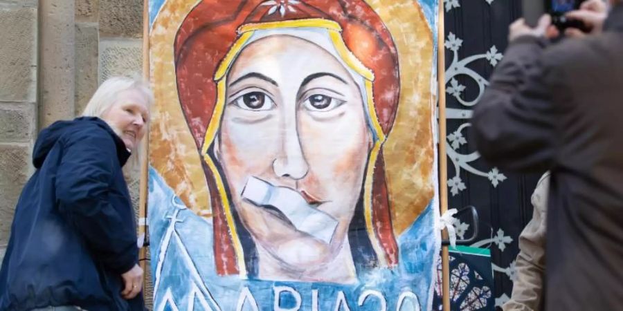 Ein Transparent beim Kirchenstreik «Maria 2.0» zeigt Maria, die Mutter Gottes, mit einem Pflaster auf dem Mund. Foto: Friso Gentsch