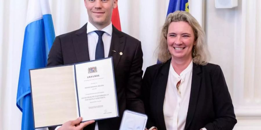 Bayern-Torwart Manuel Neuer und Sozialministerin Kerstin Schreyer bei der Verleihung der Bayerischen Staatsmedaille. Foto: Matthias Balk