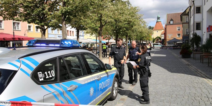 Polizeibeamte stehen bei dem Einsatz in Weiden/Oberpfalz. Eine Frau hatte im Stadtzentrum mehrere Menschen verletzt.