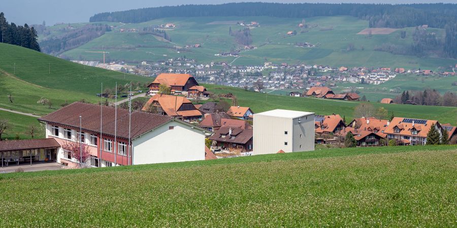 Blick auf Oberhünigen. Ganz links das Schulhaus, in der Bildmitte die Geissbühler Mühle GmbH und ganz hinten Konolfingen.