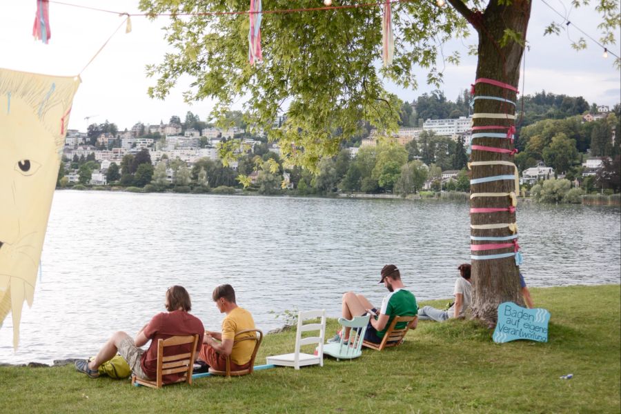 Personen sitzen am See