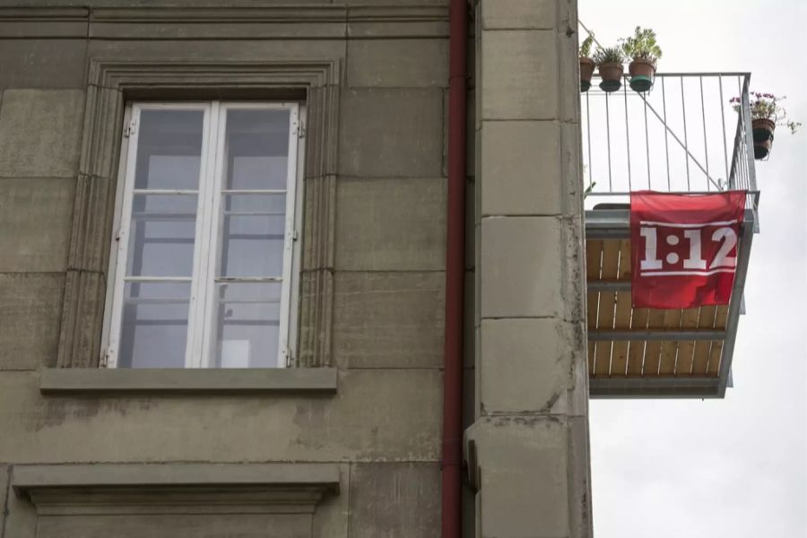 Ein Plakat für die «1:12-Initiative» hängt an einem Balkon.