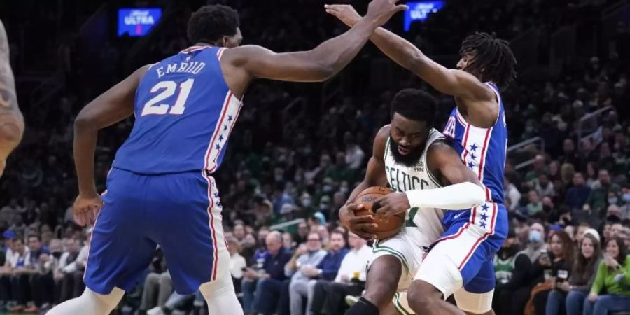 Boston Celtics-Guard Jaylen Brown (M) gegen Philadelphia 76ers-Guard Tyrese Maxey (r) und Center Joel Embiid. Foto: Charles Krupa/AP/dpa