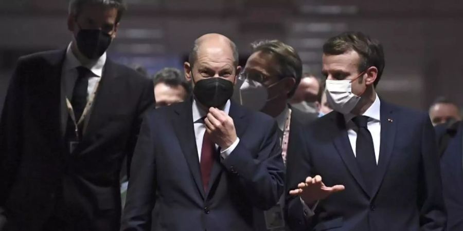 Bundeskanzler Olaf Scholz (M) und Frankreichs Präsident Emmanuel Macron (r) vor der abschliessenden Pressekonferenz des EU-Gipfels. Foto: John Thys/Pool AFP/dpa