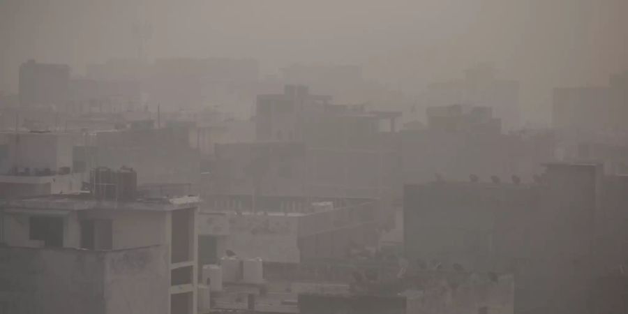 Morgendlicher Dunst und Smog hängt über der Stadt. Foto: Altaf Qadri/AP/dpa