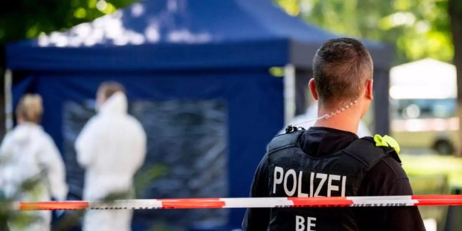 Ein Polizeibeamter sichert nach dem sogenannten «Tiergartenmord» in Berlin im August 2019 den Tatort. Foto: Christoph Soeder/dpa