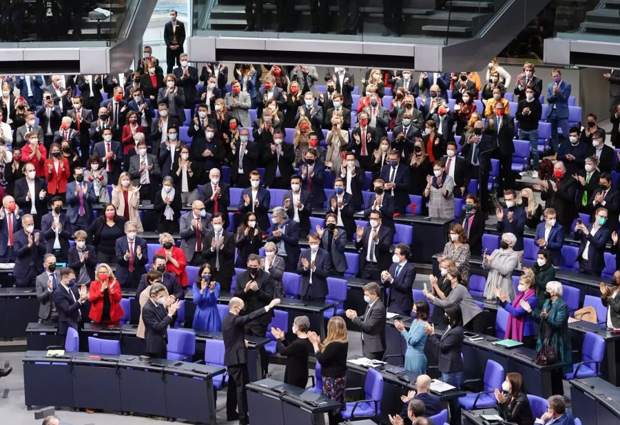 Die Abgeordneten applaudieren Olaf Scholz (M unten, SPD) nach seiner Wahl zum Bundeskanzler.